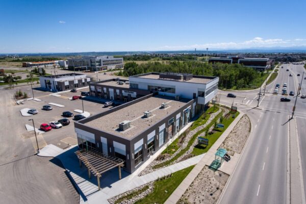 Outside view of commercial real estate complex. Storefronts and office building.